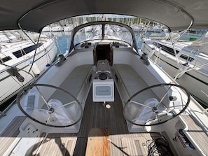 A boat deck with a steering wheel, a Garmin device, and a wooden floor. - Sun-Kissed Sailing Adventure in Northern Croatia (Punat)