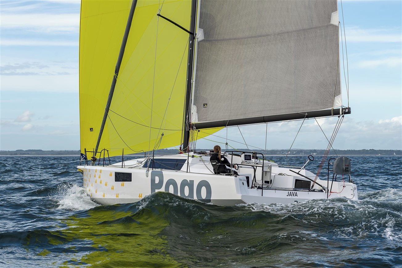 Een zeilboot met de naam 'Pogo' op de zijkant, die over het water vaart.
