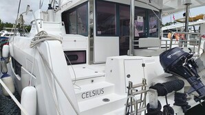 Ein weißes Boot mit der Aufschrift 'CELSIUS', eine Kabine mit Fenstern und ein Motor mit der Bezeichnung 'TOMATSU'.