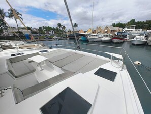 A boat deck with seating, a table, and a view of the marina. - Caribbean Dream: Sun-Kissed Sailing Adventure from Guadalupe, Grande-Terre (Pointe-à-Pitre)