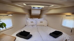 Ein kleines Schlafzimmer mit Etagenbett, einer Dachfensterkuppel, einem Tisch und einem Blumentopf.