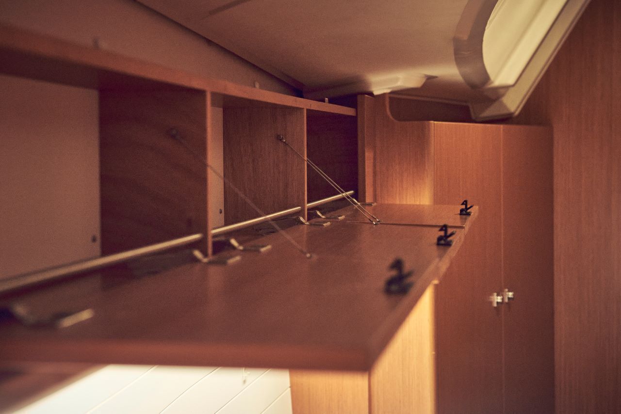 A wooden room with a built-in desk, a shelf, and a door.