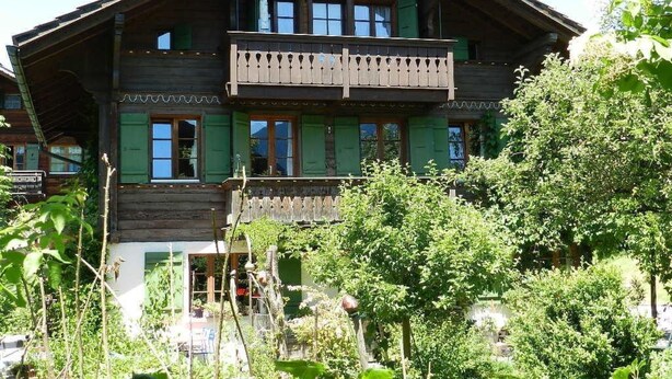 Ein Holzhaus mit Balkon und mehreren Fenstern.