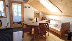 Ein gemütliches Zimmer mit einem Holztisch, Stühlen, einer Couch und einem Bett.