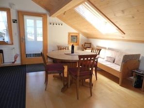 A cozy room with a wooden dining table, chairs, a sofa, and a bed. - Im Wiesengrund Appartement/Fewo, Dusche oder Bad, WC 4-Bettwohnung by Interhome (Gstaad)