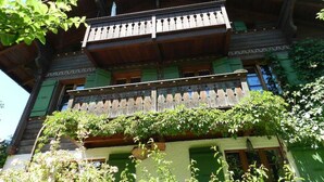 Ein traditionelles Holzgebäude mit Balkon und grünen Fensterläden.