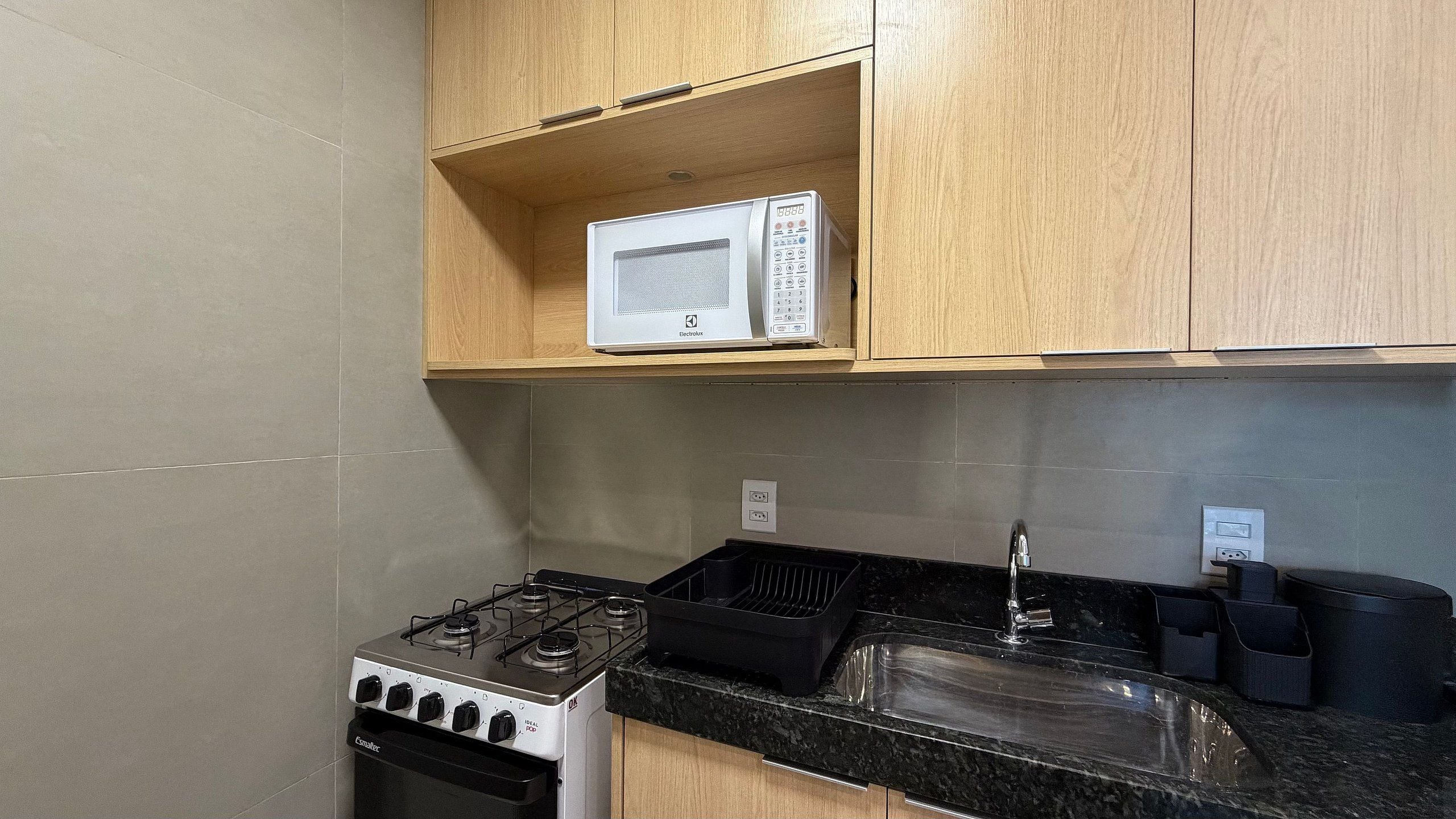 A kitchen with a gas stove, a microwave, and a sink.