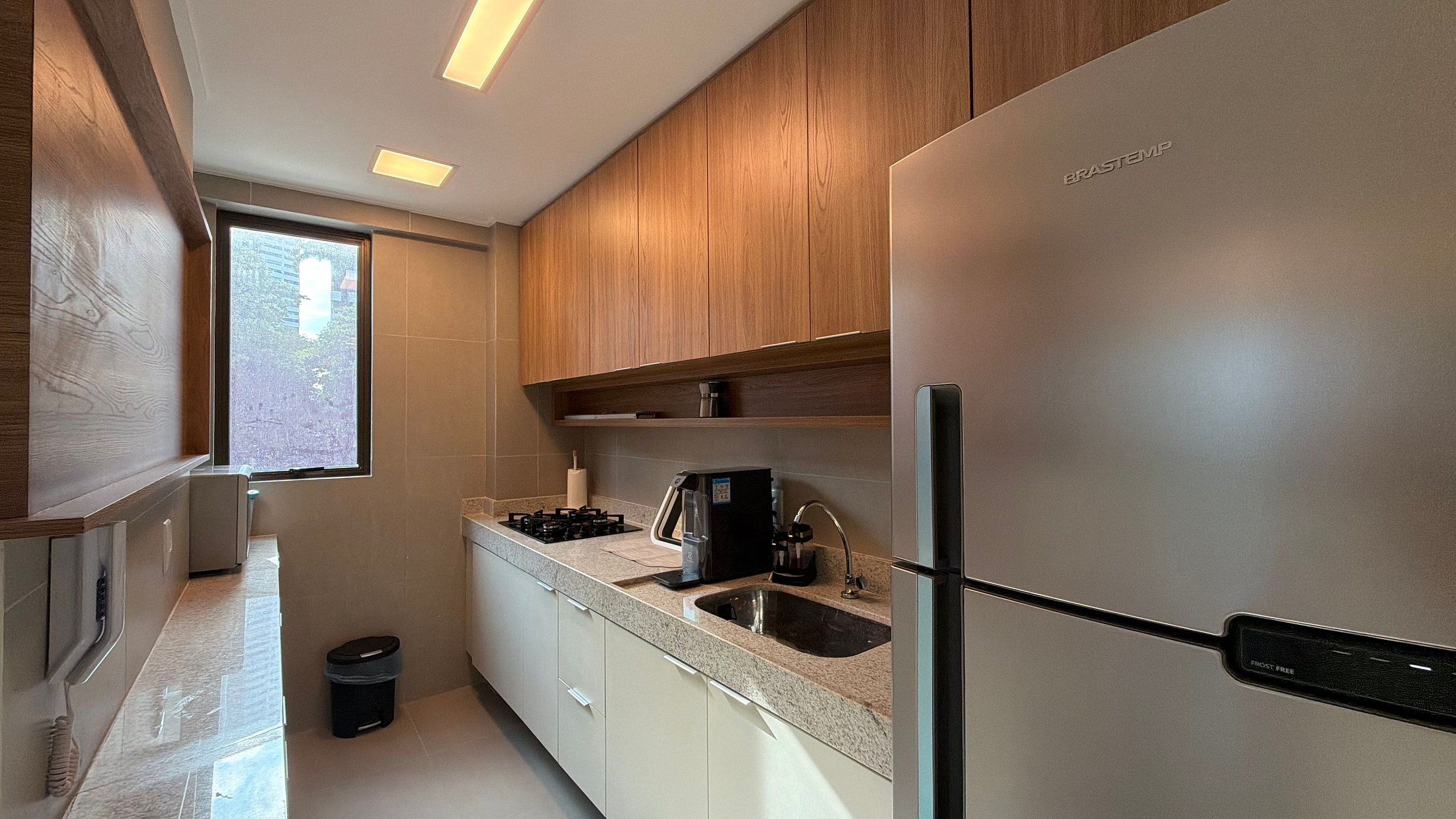 Una cocina moderna con electrodomésticos de acero inoxidable, gabinetes de madera y encimera de granito.