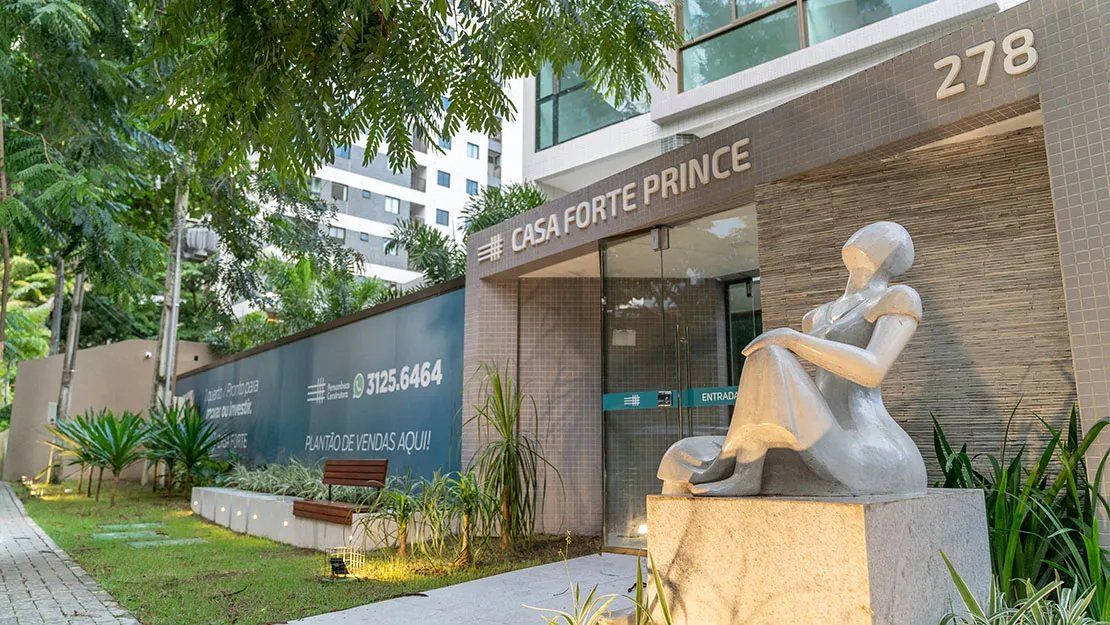 Um edifício com uma placa indicando 'CASA FORTE PRINCE' e uma escultura de uma figura sentada.
