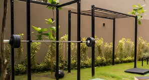 Un espace dédié à l’haltérophilie, équipé d’un support pour les squats, d’une barre et de disques de poids.