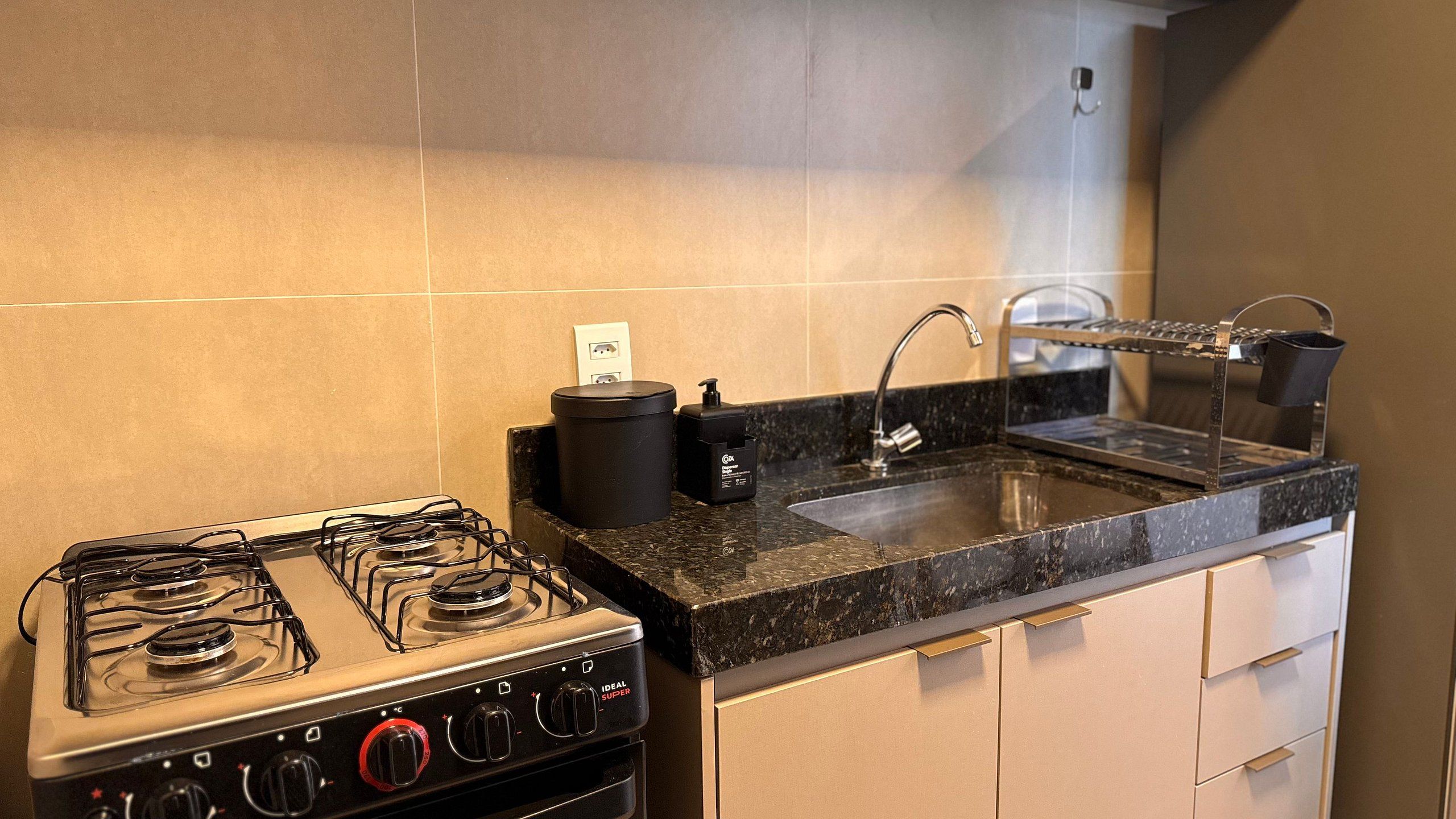 Une cuisine équipée d’une cuisinière à gaz, d’un évier et d’une machine à café.