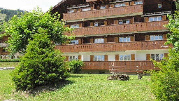 A multi-story wooden building with balconies, surrounded by greenery. - Monique Nr. 14 Appartement/Fewo, Dusche oder Bad, WC 5-Bettwohnung by Interhome (Gstaad)