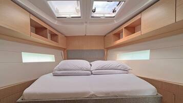 Une chambre à coucher moderne et compacte, dotée d’un lit, de fenêtres de toit et de rangements intégrés.