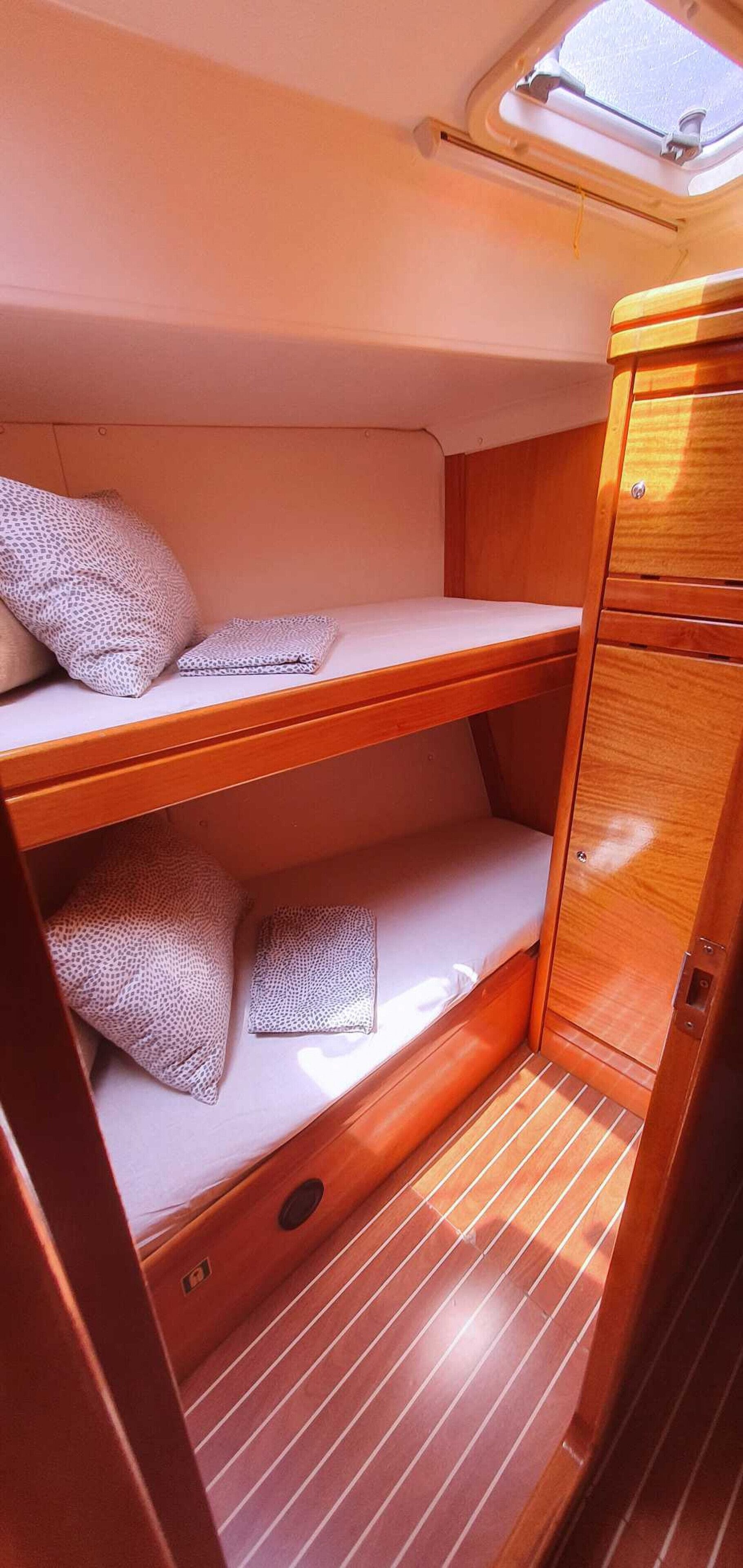 Una cabaña pequeña con una litera, un ventanal y un armario de madera.