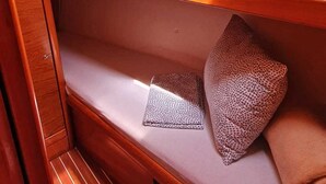 Een chalet met houten inbouwkasten, een raam en een stapelbed met opvallende kussens.