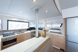 A modern kitchen with a built-in oven, a sink, and a large window. - Sun-Kissed Sailing Adventure in the Ionian Islands, Lefkada (Lefkada)