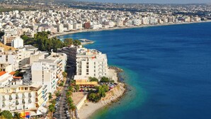 Un paisaje costero urbano con un hotel en primera línea de playa, mar azul cristalino y edificios densos.