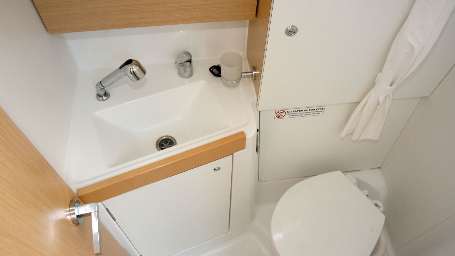 A compact bathroom with a sink, faucet, and toilet.
