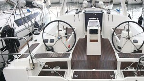 Ein Bootsdeck mit zwei Steuerwälzen, einer Mittelkonsole und einem Holzboden.