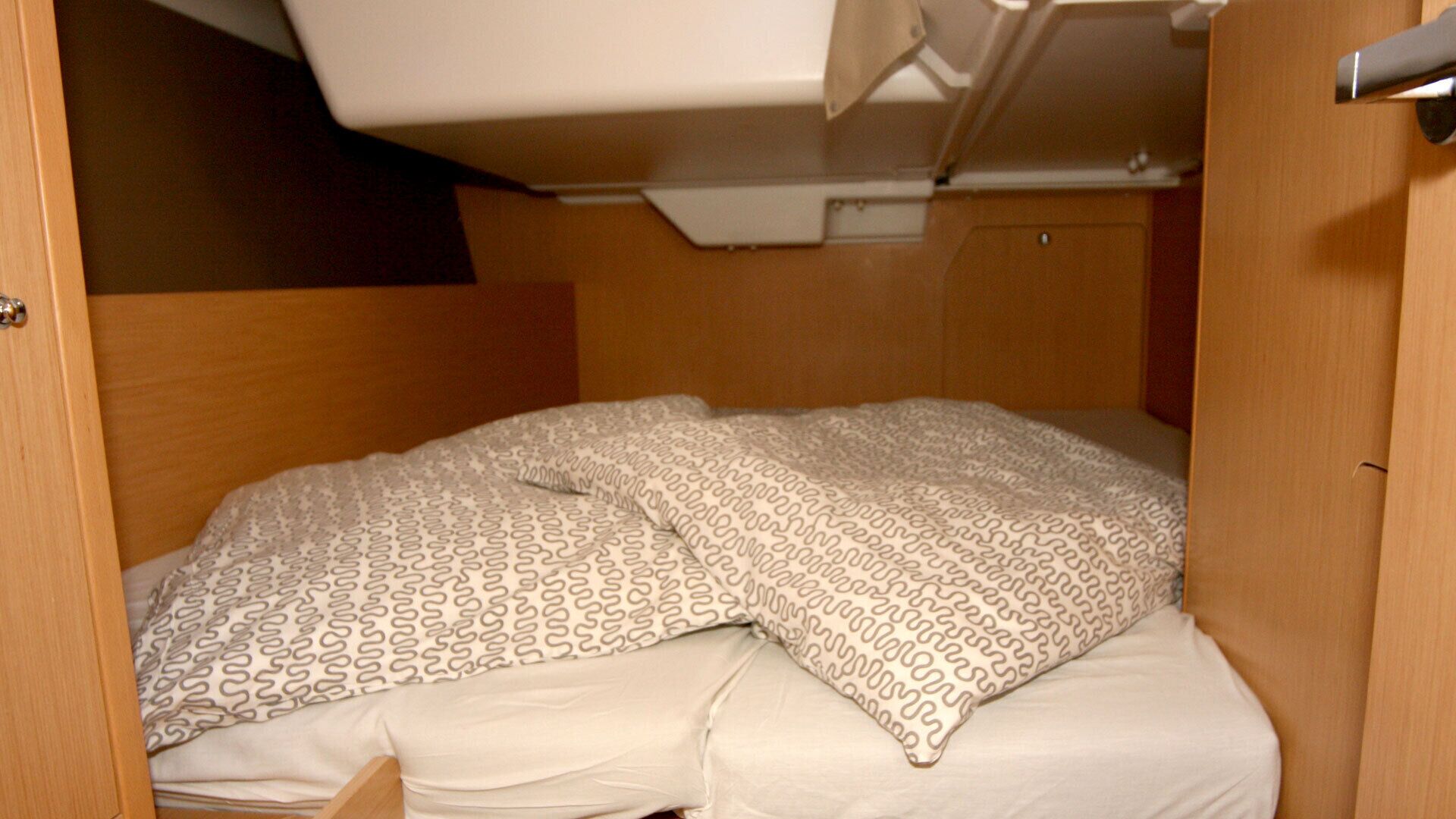 A bunk bed with patterned pillows and a wooden headboard.