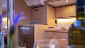 Una cocina compacta con armarios de madera, un refrigerador de acero inoxidable y una pequeña encimera.