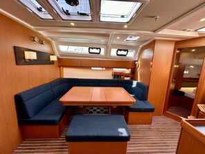 Un intérieur compact et bien éclairé, avec un espace salon central, une petite table et un coin cuisine.