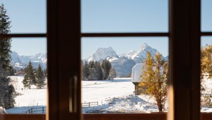A view through a window with a wooden frame, featuring a snowy landscape with mountains in the background. - Fichte (Marija) Appartement/Fewo, Dusche und Bad, WC, 2 Schlafräume by Interhome (Gstaad)