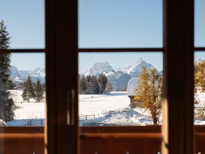 A view through a window with a wooden frame, featuring a snowy landscape with mountains in the background. - Fichte (Marija) Appartement/Fewo, Dusche und Bad, WC, 2 Schlafräume by Interhome (Gstaad)