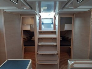 A compact interior with a central aisle, wooden walls, and a small table at the end. - Sun-Kissed Sailing Adventure in Zadar, Croatia (Biograd na moru)