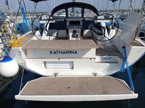 Ein Boot namens 'KATHARINA SPLIT' mit Holzboden, Steuerrad und verschiedenen Navigationsgeräten.