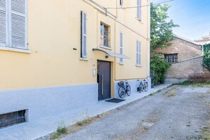 Ein gelbes Gebäude mit Tür, Fenstern und einem Fahrrad davor.