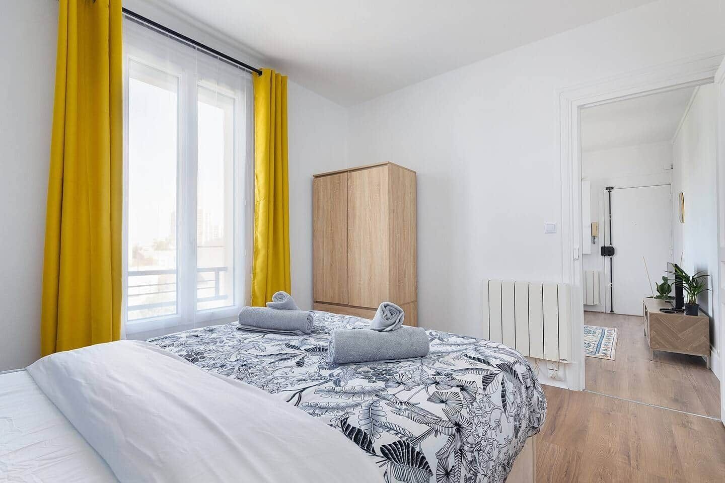 Un dormitorio con cama, armario, radiador y puerta que da a otra habitación.