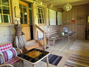 Un interior de madera con una escalera, una mesa con revistas y una cesta de mimbre.