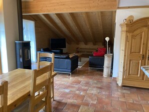 A rustic interior with a wooden dining table, a sofa, a television, and a cabinet. - Fichte (Sulliger) Appartement/Fewo, Dusche oder Bad, WC 6-Bettwohnung by Interhome (Gstaad)
