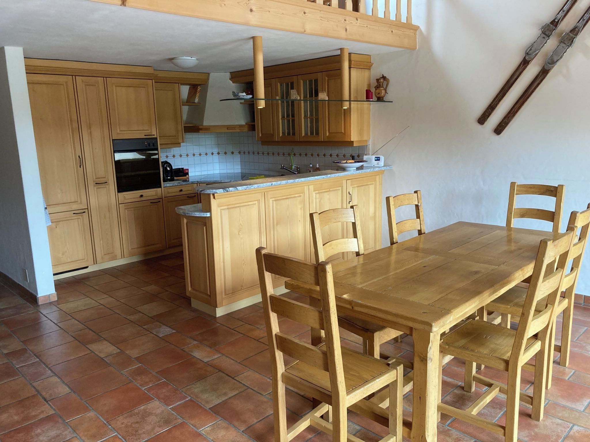 Eine Küche mit Holzausstattung, einem Esstisch und Stühlen.