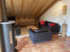 A cozy living room with a fireplace, a sofa, and a coffee table. - Fichte (Sulliger) Appartement/Fewo, Dusche oder Bad, WC 6-Bettwohnung by Interhome (Gstaad)
