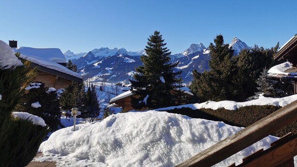 Paesaggio montano innevato con cielo sereno.