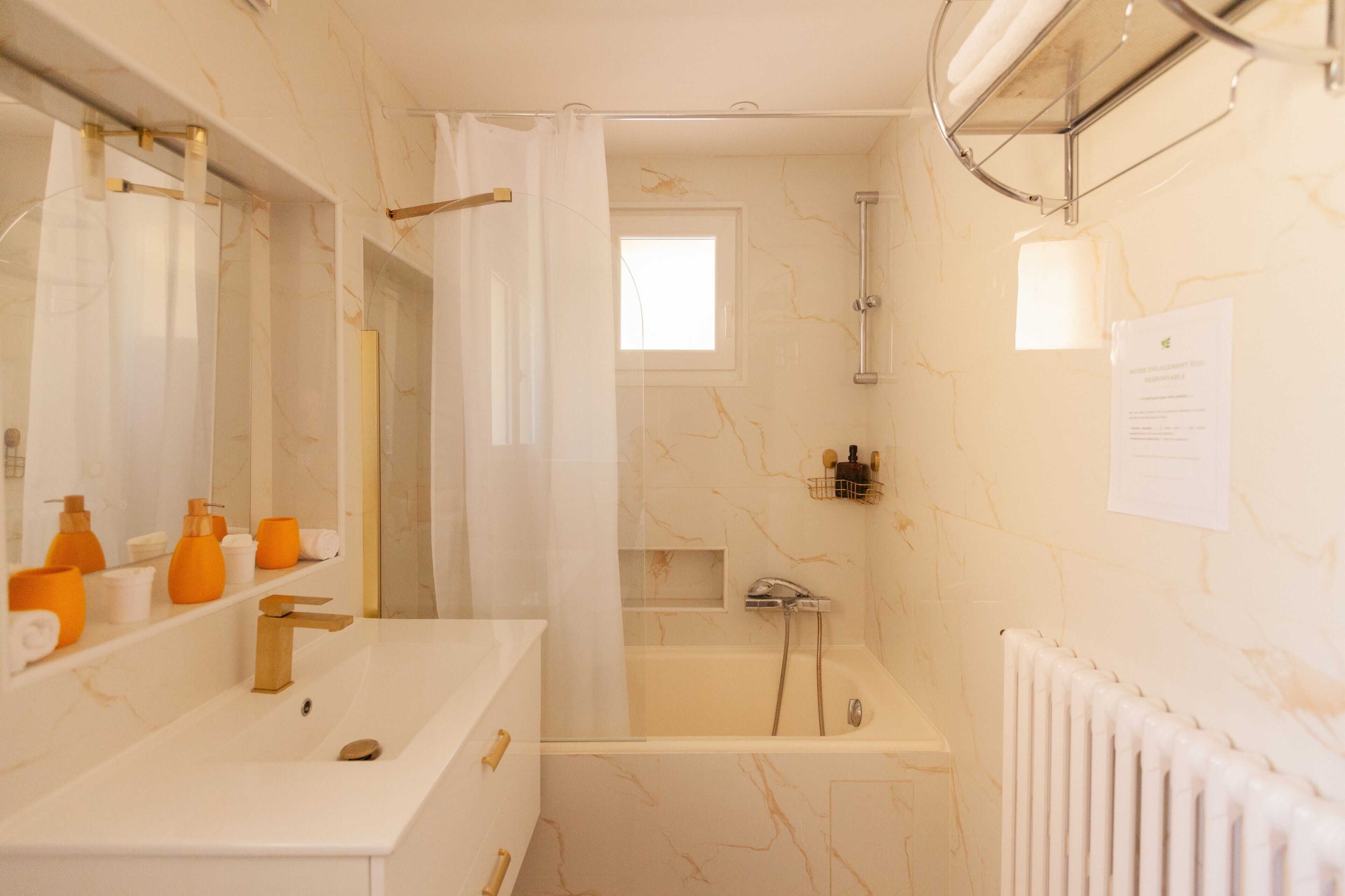 A bathroom with a bathtub, a shower, a sink, and a mirror.