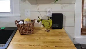 Una cucina con mensole di legno, un cesto, una ventola e una lavastoviglie.
