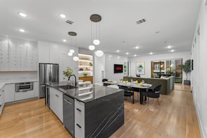 A modern kitchen with a central island, built-in appliances, and pendant lighting. - 360 City Views+Pool, Hot tub, Sauna, Rooftop (Dallas)