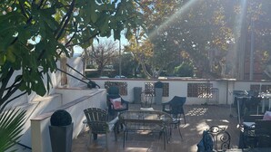 An outdoor patio area with a seating arrangement, a potted plant, and a view of the surrounding area. - NEMO Apartment by Ateya - L'Estaque (Marseille)