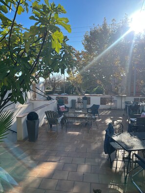 An outdoor patio area with a seating arrangement, a potted plant, and a view of the surrounding area. - NEMO Apartment by Ateya - L'Estaque (Marseille)