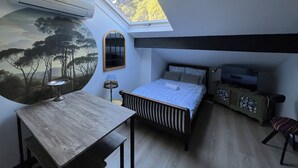 A bedroom with a skylight, a bed, a desk, a chair, and a TV. - NEMO Apartment by Ateya - L'Estaque (Marseille)