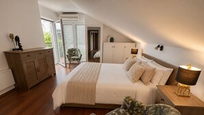 A bedroom with a bed, a chair, a nightstand, and a cabinet.