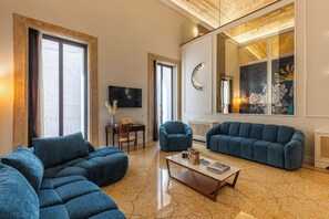 A spacious living room with a sectional sofa, a coffee table, and a TV.