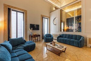 Un salón amplio con un sofá modular, una mesa de centro y un televisor.