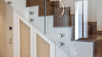 Una escalera moderna con barandillas de vidrio y escalones de madera.