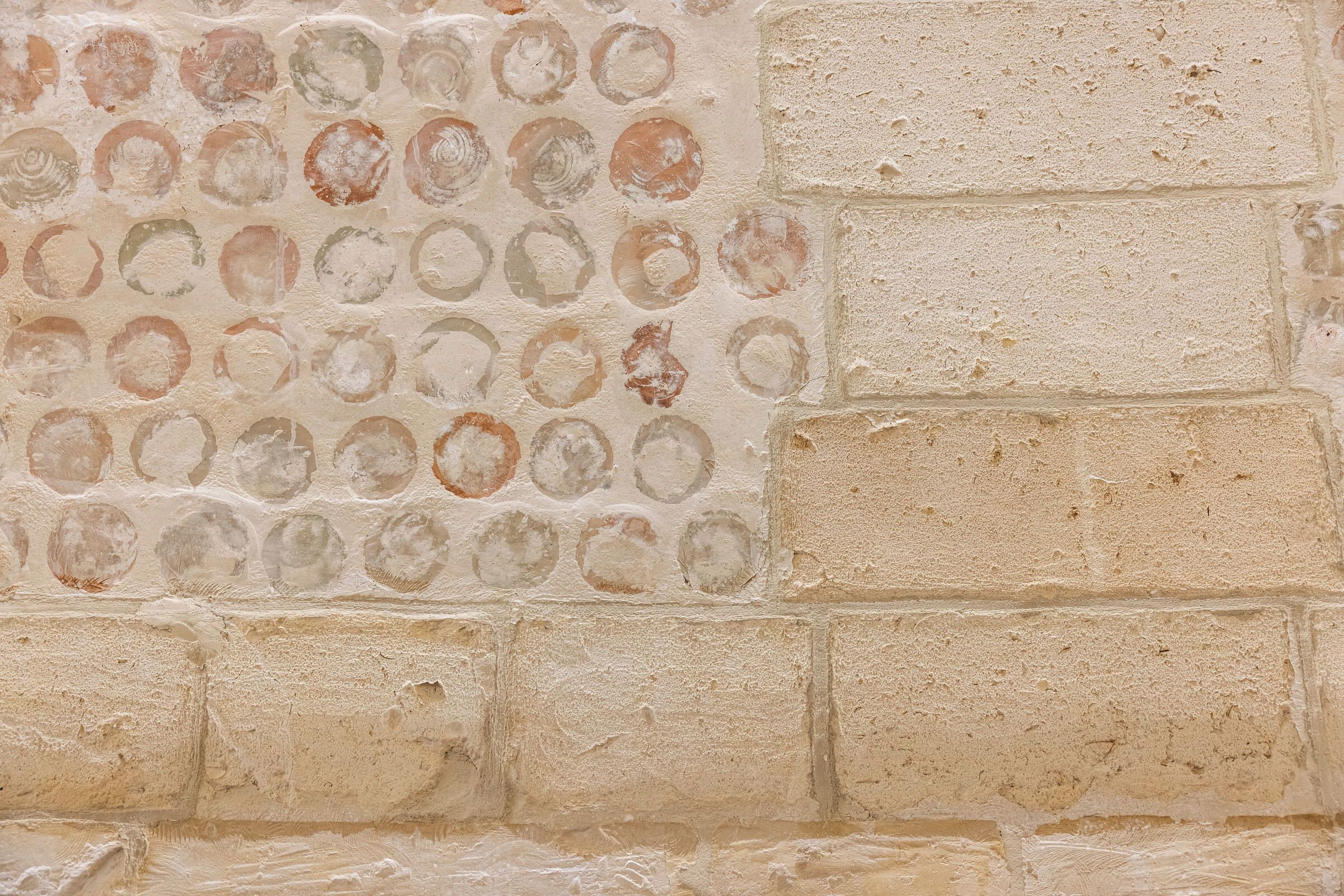 A textured wall with circular patterns and rectangular blocks.