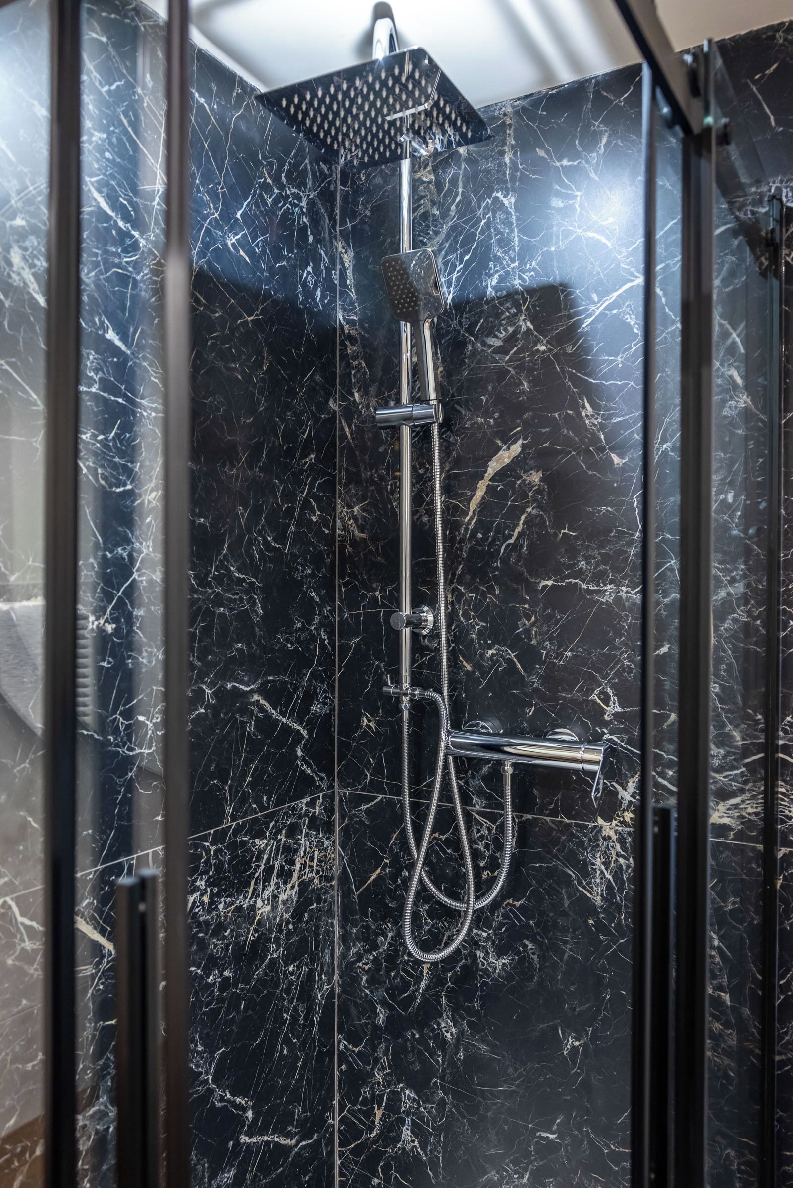 A shower with a handheld showerhead and a rain shower head.