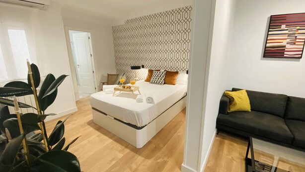 A modern bedroom with a bed, bedside table, and a black and white patterned wall. - C Madrid R o Est Ndar 2 Personas (Madrid)